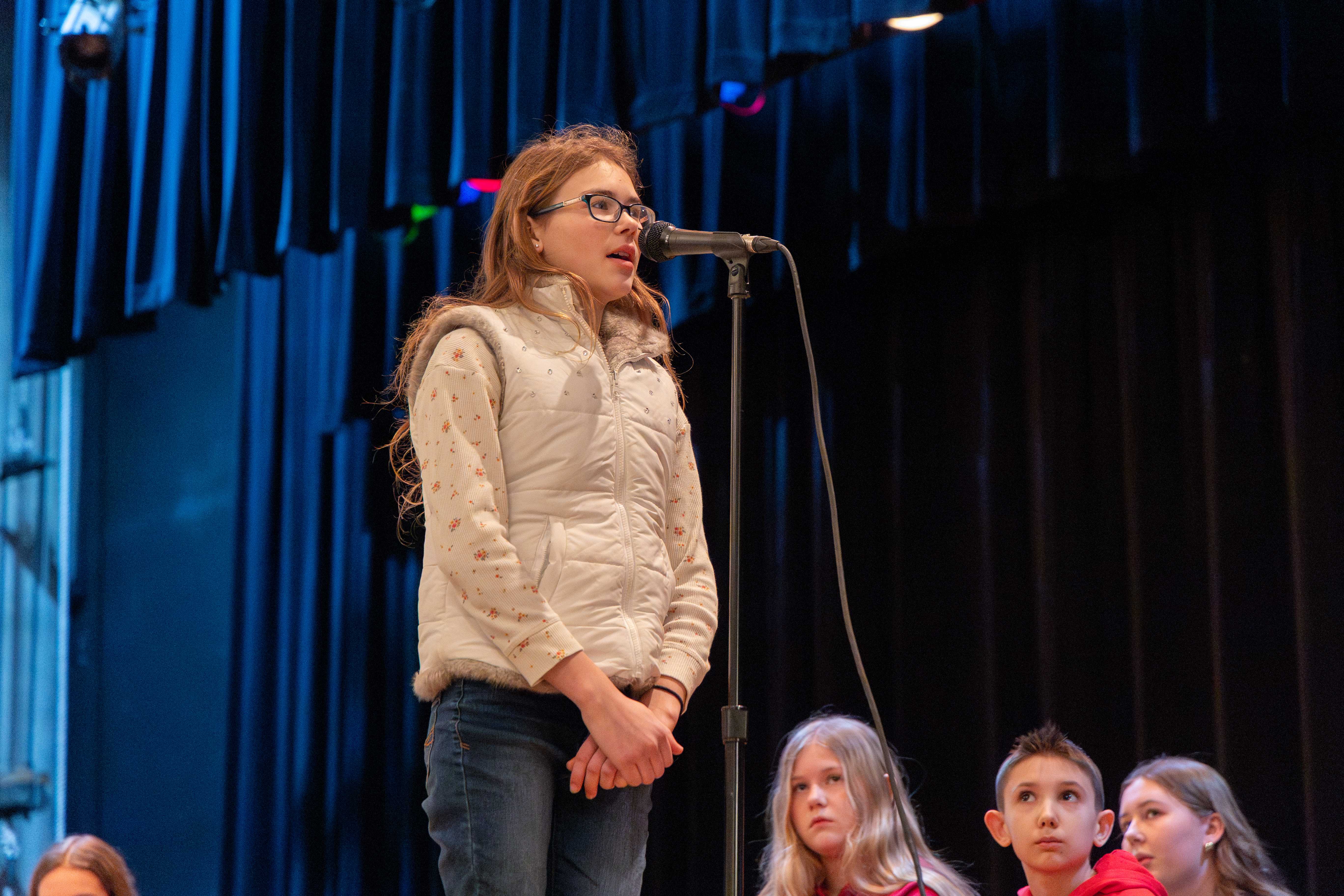 A student spells a word at the microphone